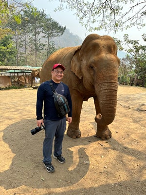 Choi stands next to an elephant