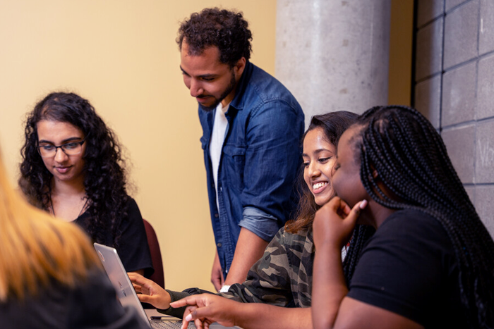 An instructor helps three students