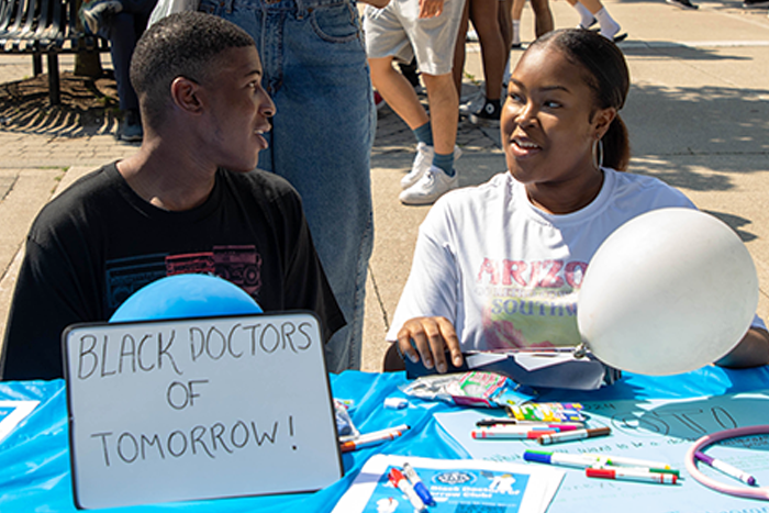 Black students sit at a table at the clubs fair