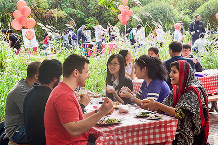 International students sit outside during orientation