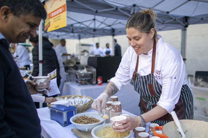 A person serves food to another person