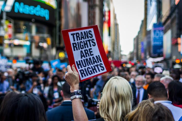 Woman holding trans rights banner