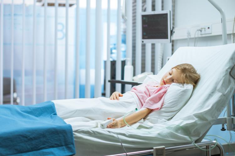 A young girl sleeps in a hospital bed