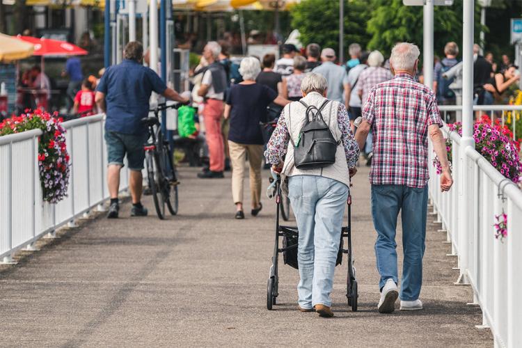 Two seniors walking across a bridge