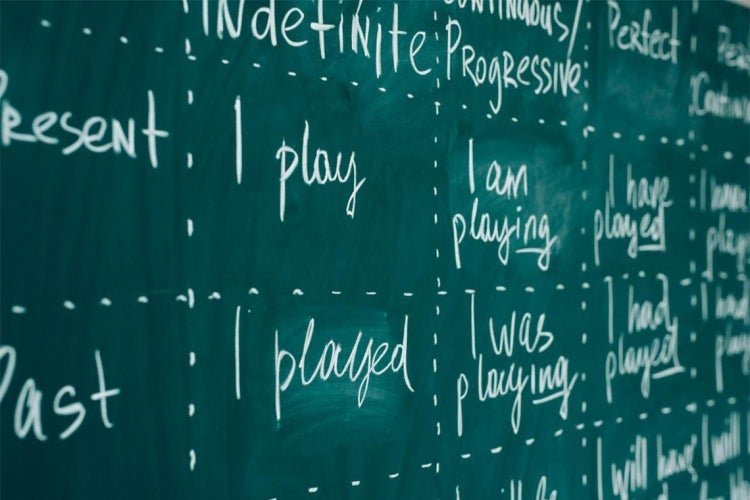 a chalkboard with different word tenses written on it