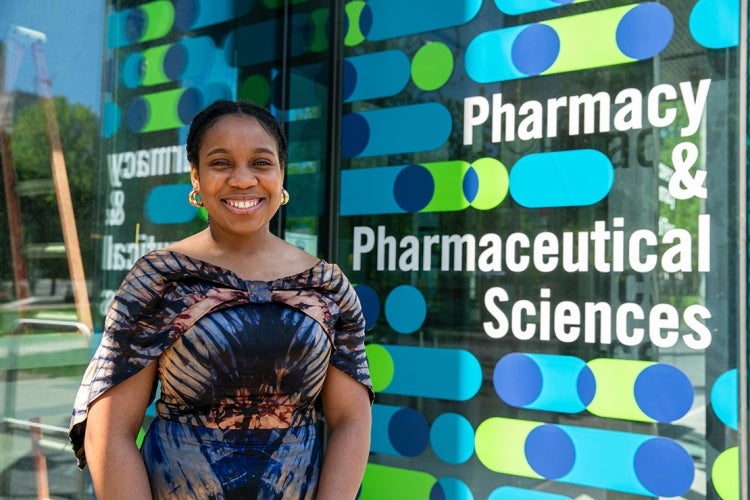 Theodora Udounwa stands outside the Pharmacy building signage