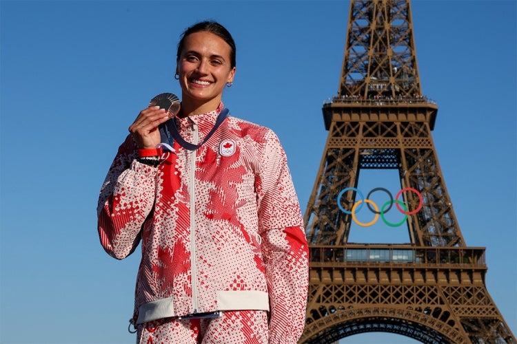 Kyli Masse holds up her bronze medal in front of the Eiffel Tower at the 2024 summer olympics