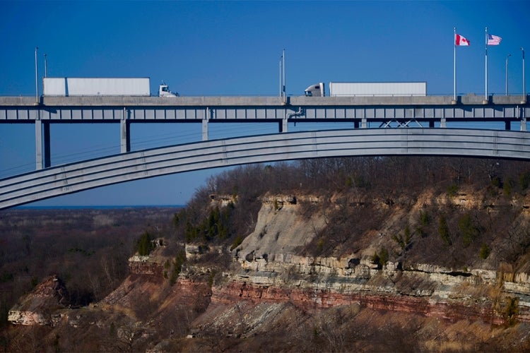 two trucks crossing in opposite directions at the queenston-lewiston bridge near Niagara Falls connecting the USA and Canada