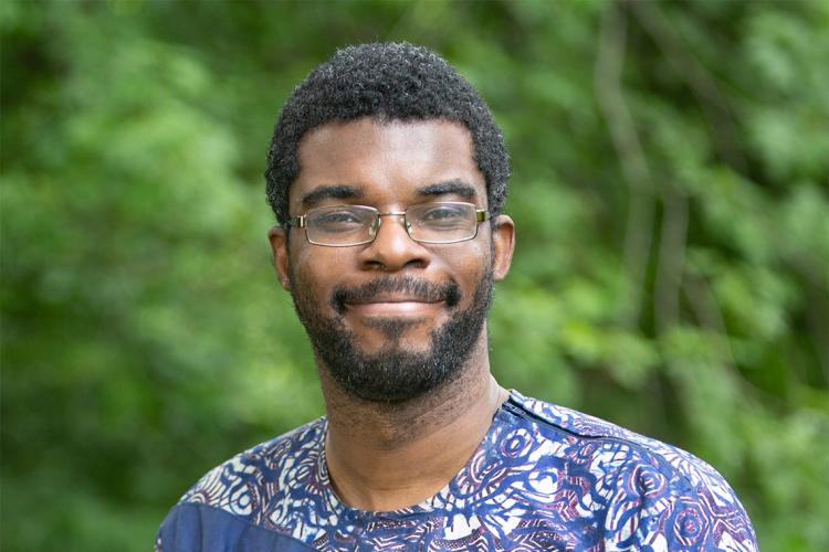 Photo of Philip Asare wearing a purple T-shirt