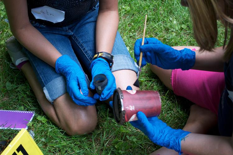 photo of students with rubber gloves dusting a Tim Hortons' cup for fingerprints