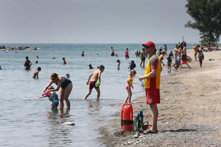 A lifeguard stands watch over swimmers at a Toronto beach