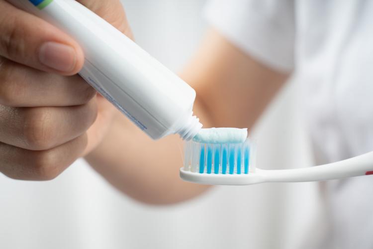 Photo of toothpaste being applied to toothbrush.