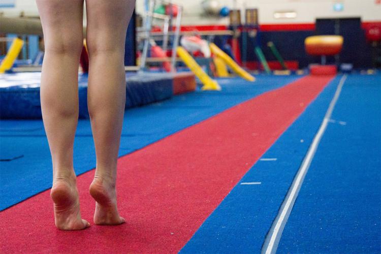 A female gymnast trains in a gym