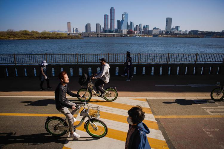 people cycling in seoul korea with a clear blue sky