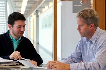 photo of Professor Blencowe and the lead researcher seated at a desk, reviewing study