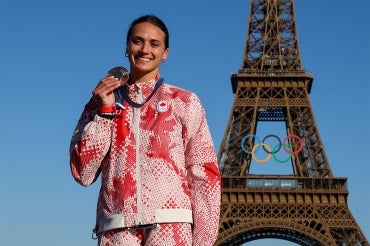 Kyli Masse holds up her bronze medal in front of the Eiffel Tower at the 2024 summer olympics