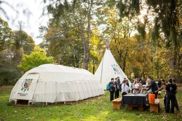 People gather outisde the teaching lodge at UTM