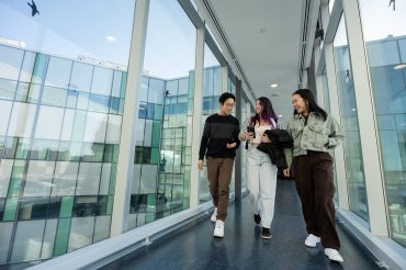 Students walk through a glass hallway at U of T Scarborough