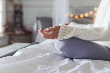 woman meditating on a bed