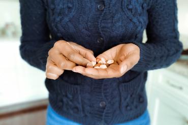 Black woman holding mixed nuts in her hand