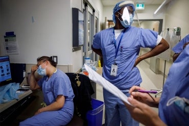 a female and male doctor look exhausted at a hospital