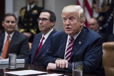 President Donald Trump speaks, with Secretary of Treasury Steven Mnuchin by his side