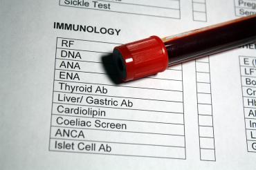 Vial of blood rests on a blood test requisition form