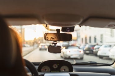 A woman looks out the windshield of her vehicle