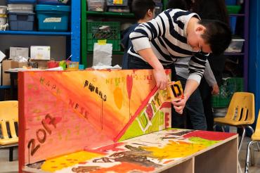 Student Josh Estrella stencilling on buddy bench at Art City