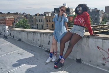 Katerina Mizrokhi and Melissa Vincent sit on a wall in New York City