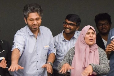 Four grinning U of T students sharing a laugh during an orientation event