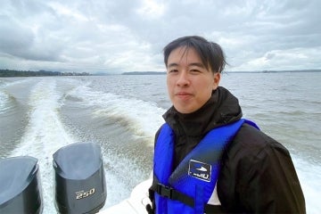 Jeff Chen is seen on a boat on a grey day