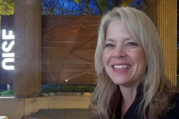Lois Maplethorpe in front of the OISE sign
