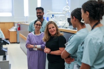Freeland smiles during a candid moment with some dentistry students