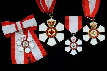 order of canada medals on a black background