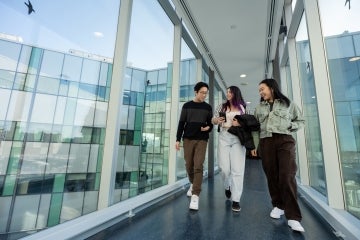 Students walk through a glass hallway at U of T Scarborough