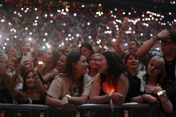 two fans share a moment singing together at a taylor swift concert in Amsterdam