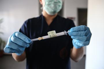 person holds a syringe filled with the stage 3 trial of the pfizer vaccine
