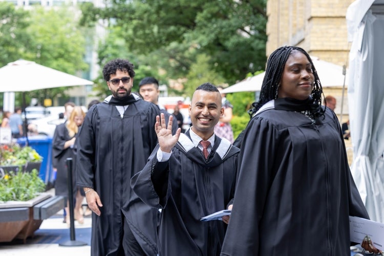 Jaivet waves to the camera before entering Convocation Hall