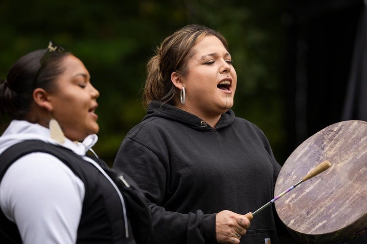 A member of the Manitou Mka Singers plays a drum while another sings