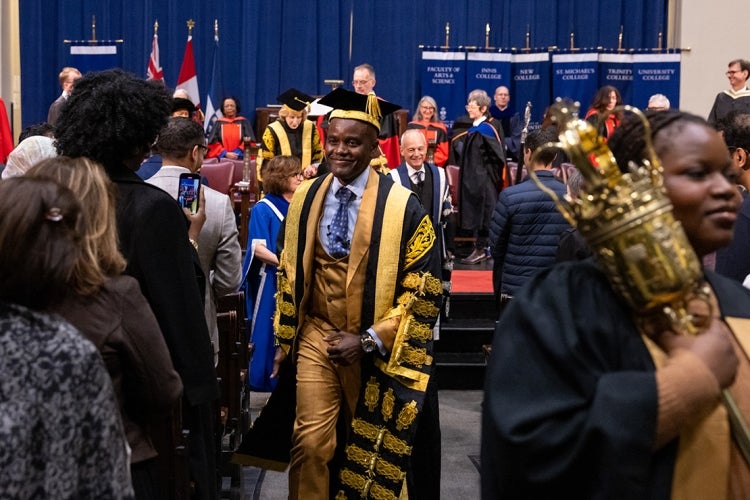 Wes Hall leaves Convocation Hall wearing his chancellor's robes