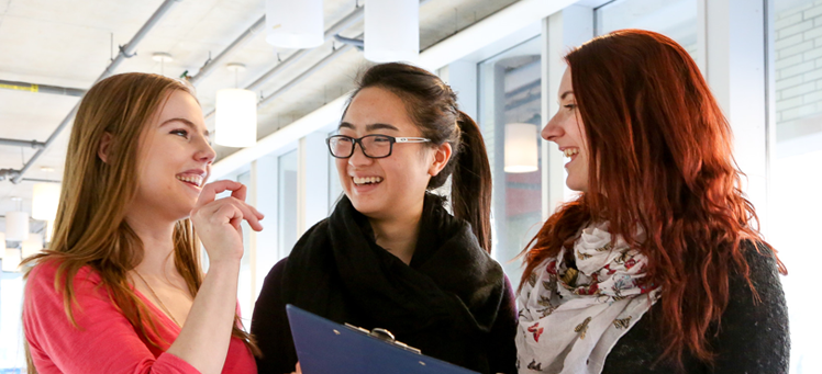 Three students talking and smiling